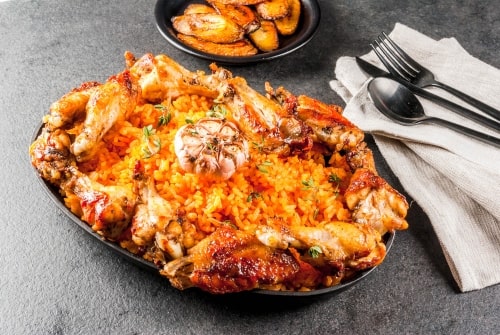 Jollof rice with chicken on a kitchen counter representing Nigerian chicken recipes.