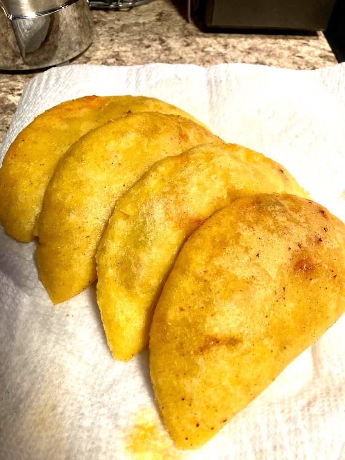 Four empanadas displayed on paper towels to represent how to make a Panamanian empanadas recipe.