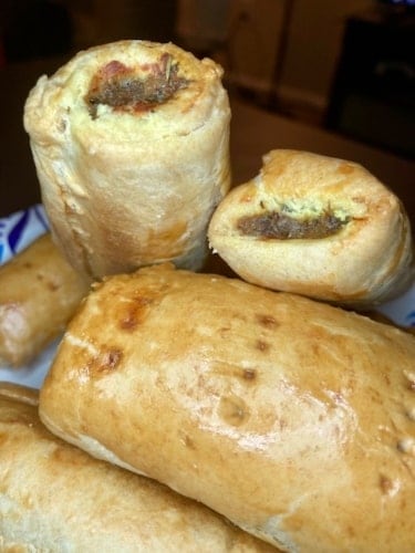 Pile of sausage rolls from Nigeria on a flat surface in the kitchen.