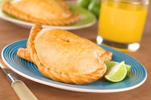 Empanadas from Peru displayed on a plate with lime wedges placed beside them.