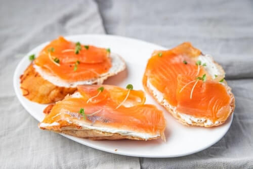 Swedish snacks smorrebrod open face sandwich on a white plate on a grey countertop.