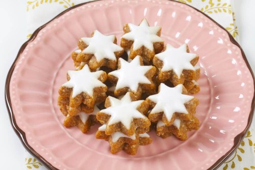 Swiss Christmas cookies shaped like stars on a pink plate.