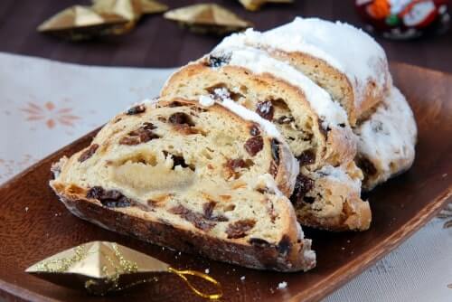 Sourdough stollen German Christmas bread on a plate with a festive holiday background.